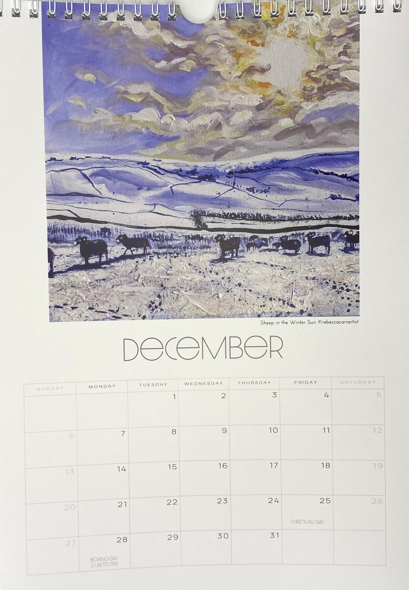 Calendar page for December with a winter landscape illustration of sheep in a field in the winter sun