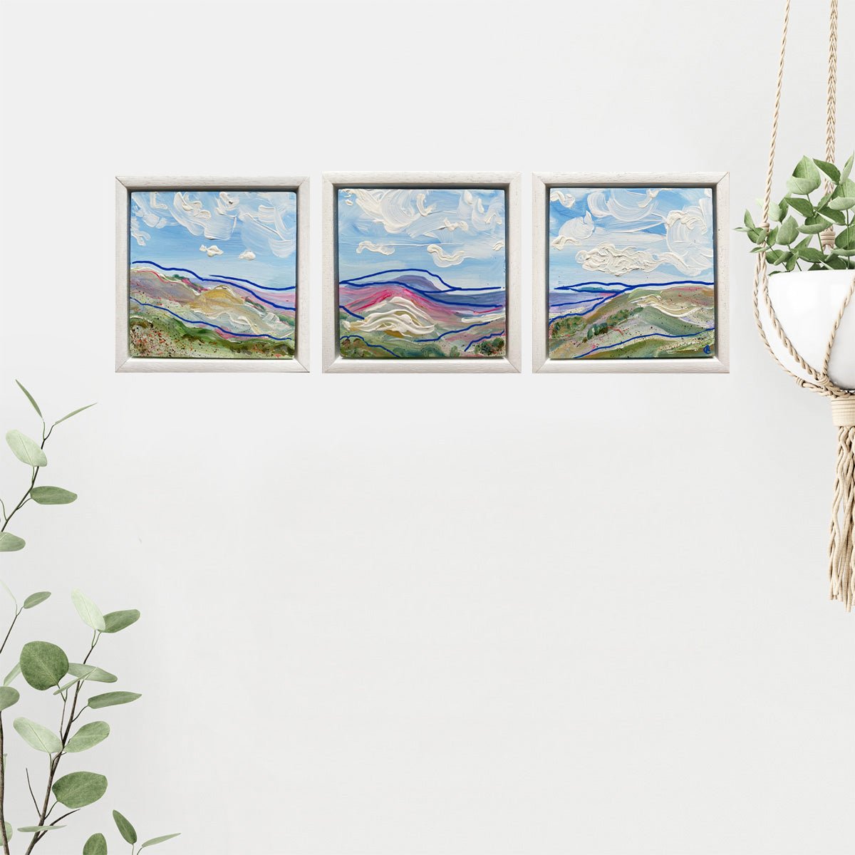 Mini abstract landscape triptych inspired by the Yorkshire Dales, painted directly on gesso block with chalk paint and acrylic in blues, white, purple, and pink, featuring fast-flowing blue lines, framed in a 15 x 15cm painted white wooden float frame.