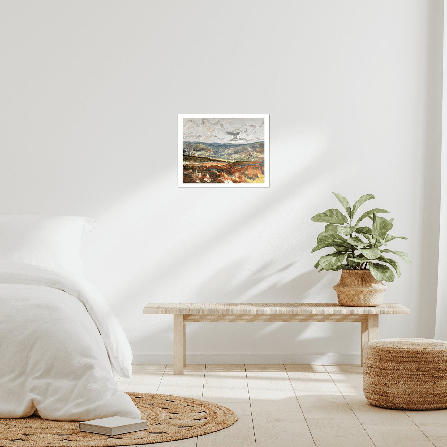 Room interior with a framed picture on the wall, a plant on a table, and a rug on the floor.