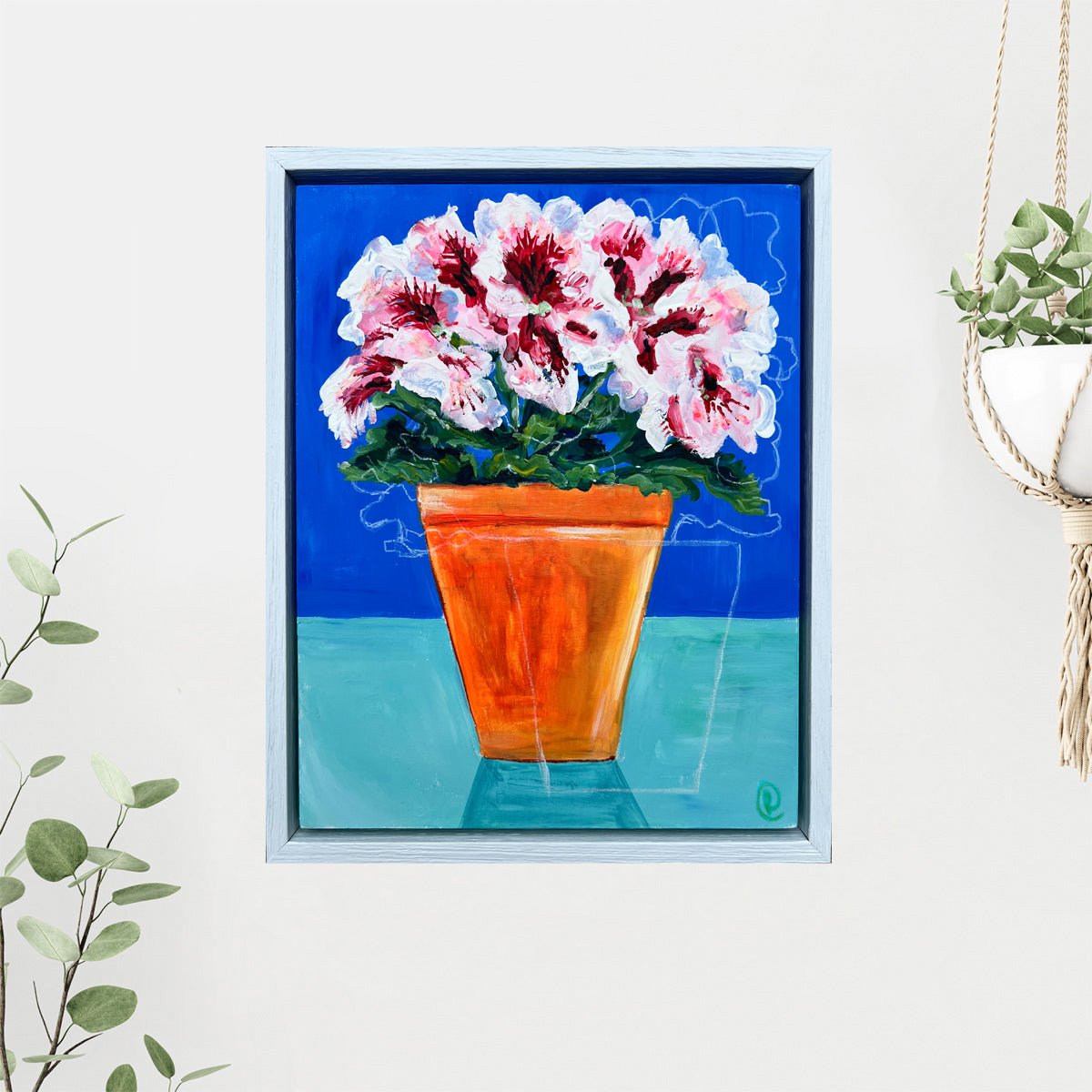 Framed painting of a potted plant with pink flowers on a blue background