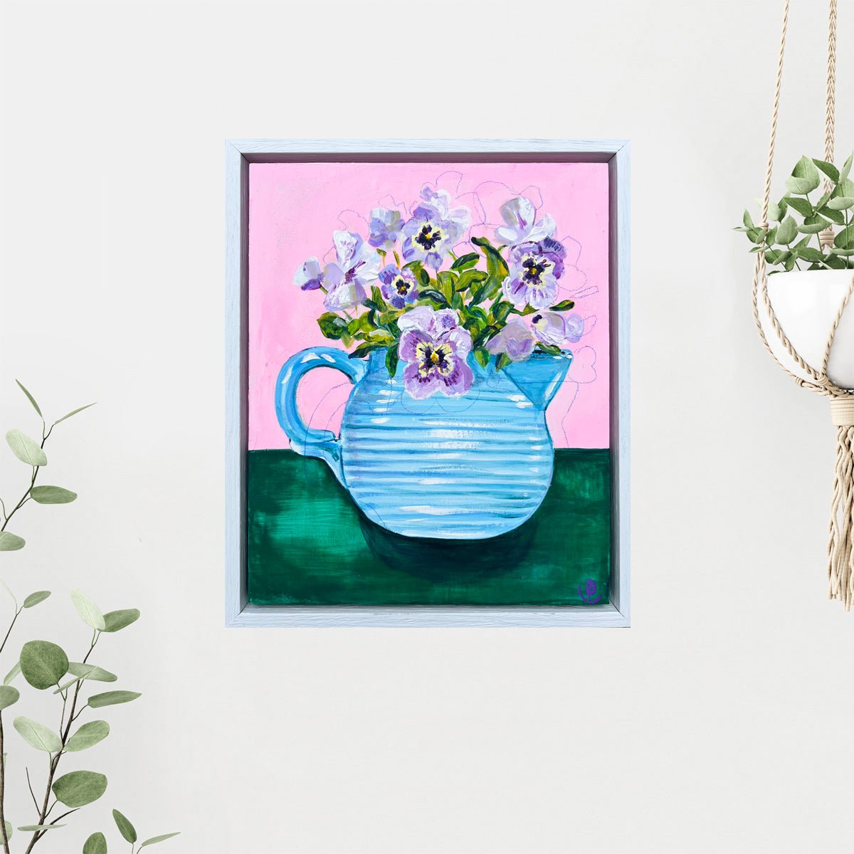 Framed artwork of a blue pitcher with purple flowers on a pink background