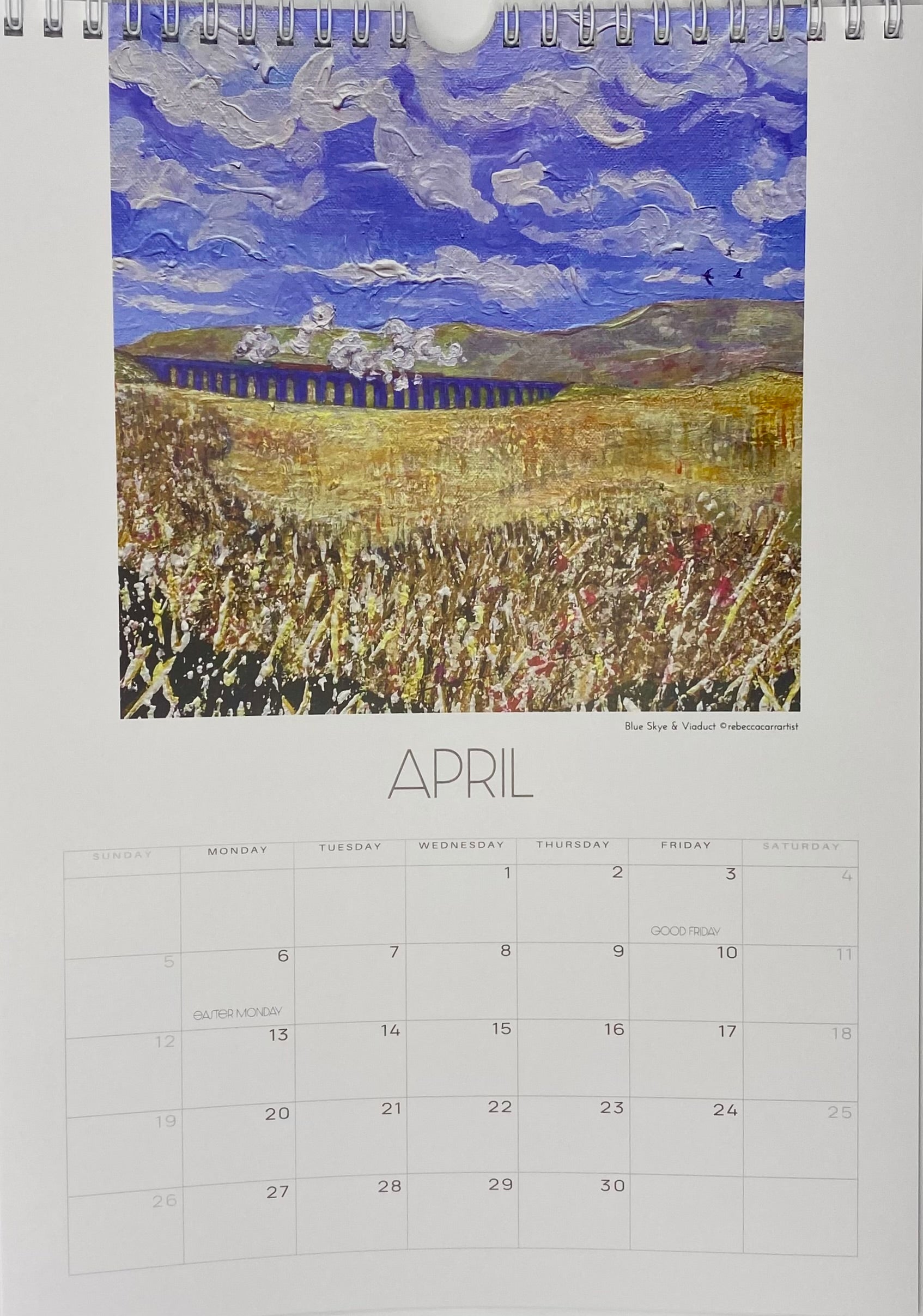 Calendar page for April with a painting of a landscape featuring a field and mountains. rebecca carr artist